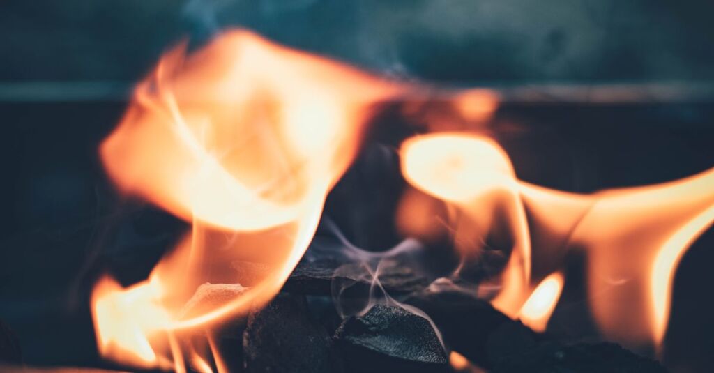 Glühende Shisha-Kohle wird mit einer Zange gehalten